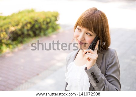 Beautiful young asian businesswoman who talks on the telephone