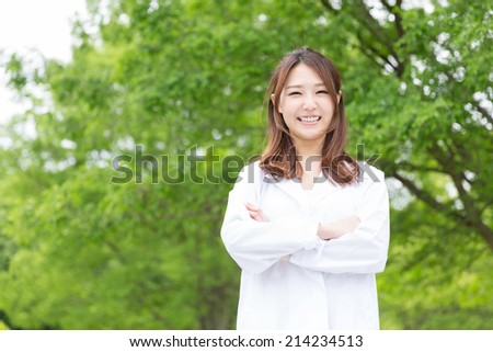Young attractive asian woman in a white coat