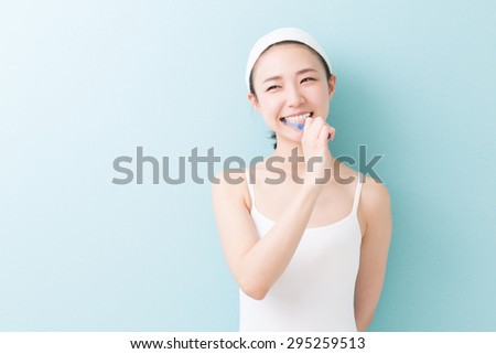 young attractive asian woman with healthy teeth holding a tooth brush