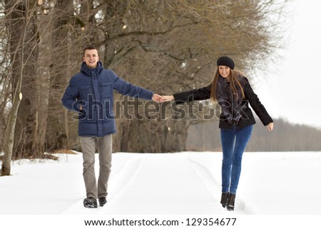 Couple walking in winter park happy and joyful