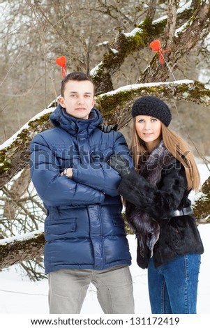 Happy Young Couple in Winter garden kissing.