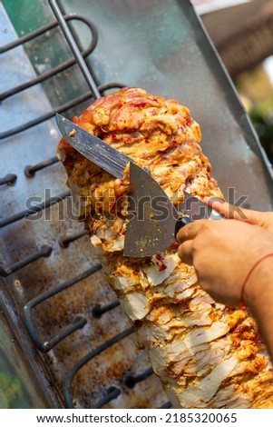 Chef cutting with doner knife Traditional Turkish Doner Kebab meat. Shawarma or gyros. Turkish, greek or middle eastern arab style chicken doner kebab food. ストックフォト © 
