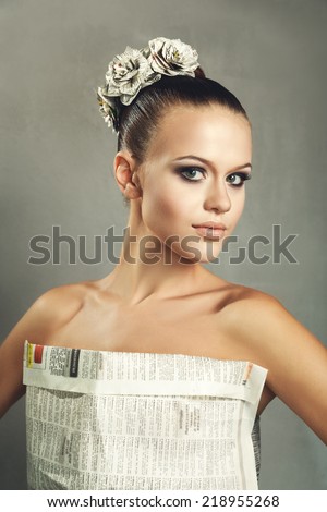 Young girl in a dress handmade paper on gray background