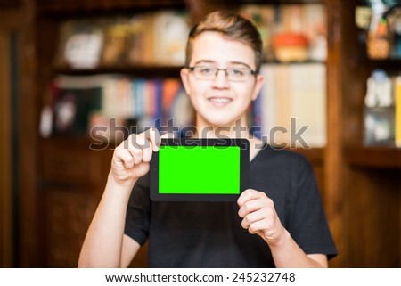 Happy young boy presenting your product in a tablet computer, chroma key