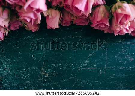 Pink roses frame, on a wooden, vintage blue tabe; with place for text