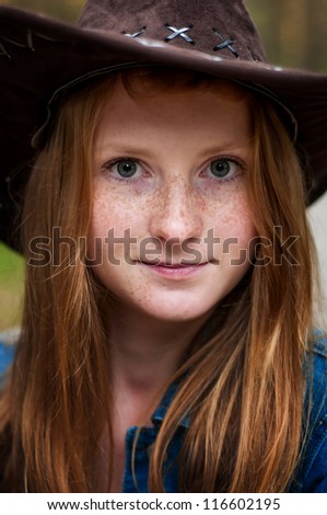 portrait of a beautiful girl-cowboy with freckles, close-up