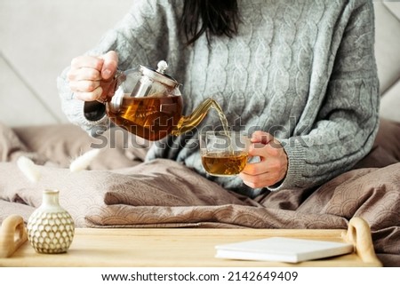 Image, Stock Photo Woman pouring green tea in mug on wooden table with green herb