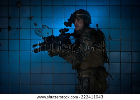 US Marine in a defensive position. Military in the destroyed building with a night vision device.