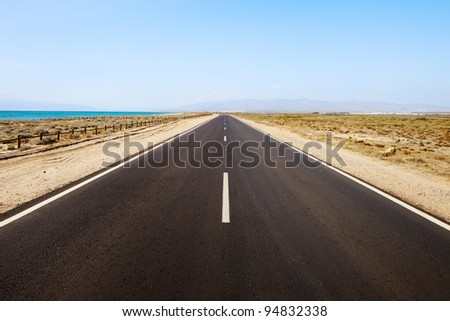 Straight road in a desert seascape. Andalusia, Spain.