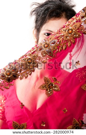 Portrait of a shy smiling Indian woman covered his face through his beautiful designer sari over white background