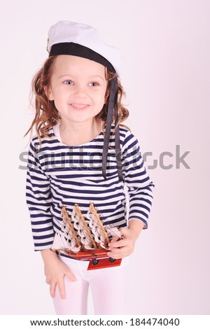 Smiling little girl holding toy ship