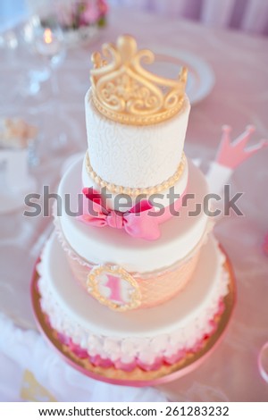 Birthday cake with golden crown on top closeup. Wedding day. Decorations.