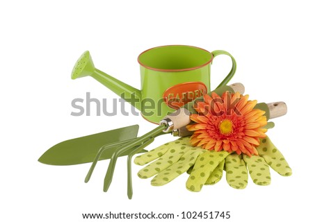new shiny gardening tools kit including trowel, cultivator, watering can with painted sign on it, gloves and flower for decoration isolated on white background