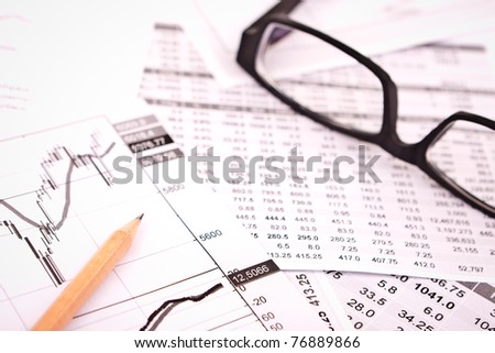 data analyzing in stock market: on the charts and quotes prints, the eyeglasses and a pencil