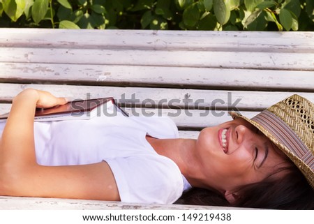 Girl sleep on the bench with book