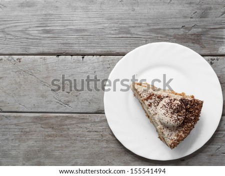 Piece of cake on the wooden table, top view, space for text
