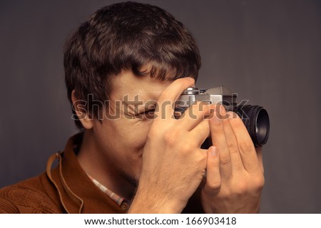 Young man looks at the old camera, space for text