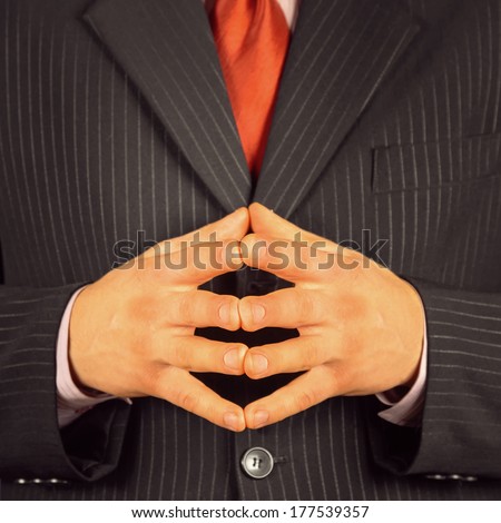 Confidence businessman with gesture hand together, face is not visible, close-up
