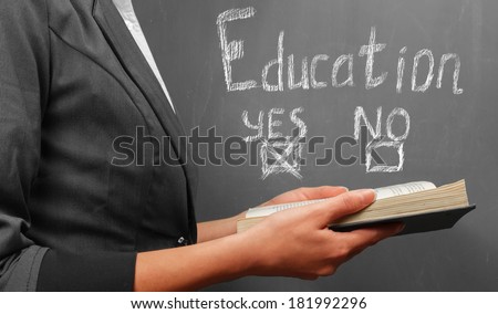 Woman holds book on a background of text education yes or no