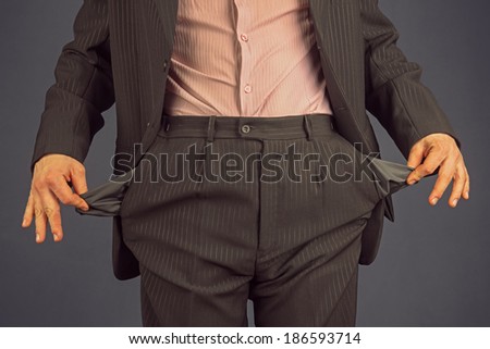 Unrecognizable man in a suit with empty pocket turned inside out