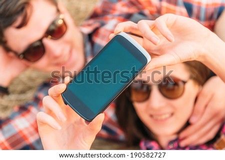 Young couple takes photographs self portrait with camera phone