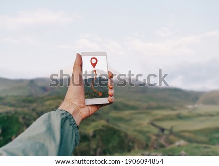 Foto Bild Nicht erkennbarer Wanderer, der mit Karte und Kompass in der Landschaft navigiert