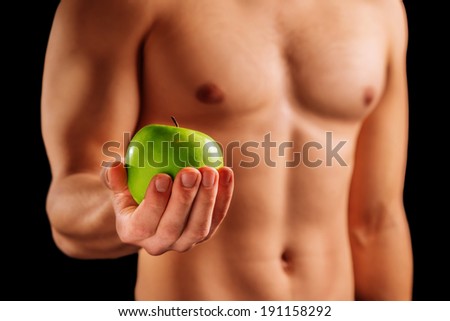 Unrecognizable strong man holds green apple, concept of healthy food