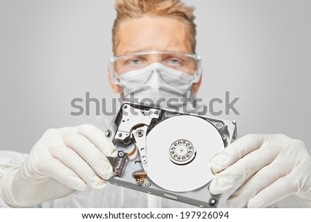 Man technician in glasses and gloves shows the hard disk