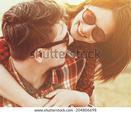 Close-up image of young happy woman embraces a man. Low contrast, with sunlight effect