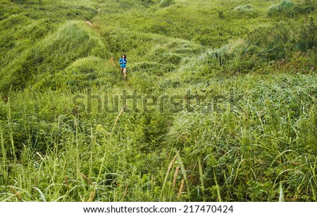 Hiker young woman walking in summer mountains, landscape, concept of little human among powerful nature