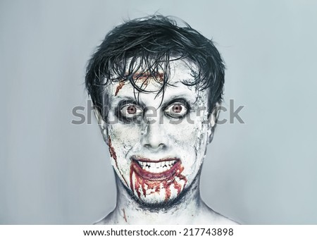 Portrait of happy man with zombie face art. Halloween or horror theme