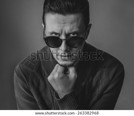 Portrait of handsome fashionable brunet man in sunglasses. Black and white image
