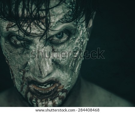 Portrait of terrible zombie man in blood, Halloween or horror theme. Space for text in right part of the image