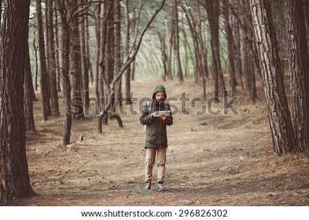 Hiker young woman searching something on digital tablet in the forest