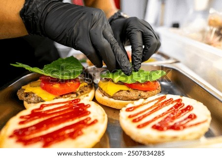 Image, Stock Photo Chef preparing burgers at grill plate on international urban street food festival.