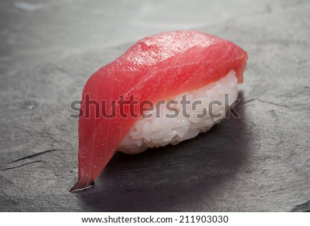 Japanese Sushi dish of rice with tuna on matte black background close-up.