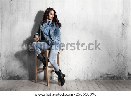 Girl in jeans sitting on wooden chair