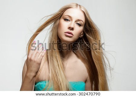 Blonde woman with shiny long hair flying