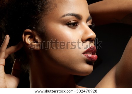 Portrait of a black woman in profile close-up on a black background