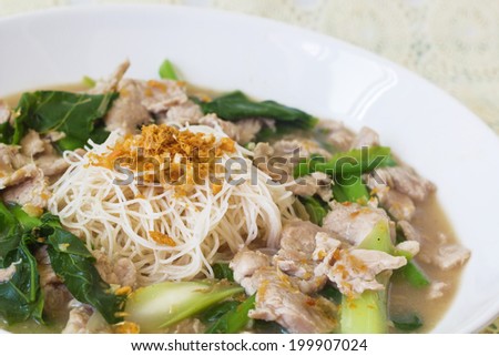 vermicelli noodles topped with pork and kale