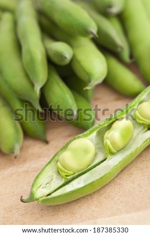broad bean pods on wooden board