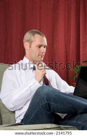 businessman sitting on couch with black laptop