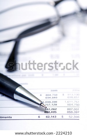 accounting report showing dollar figures with a pen