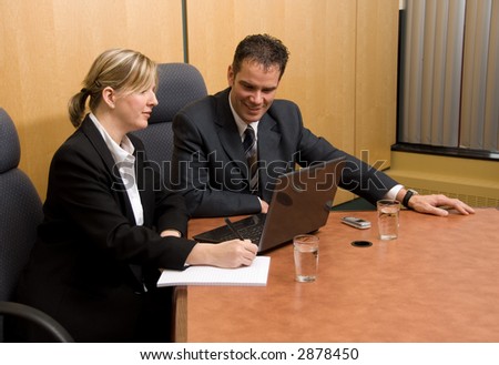 business colleagues in a board room with a laptop