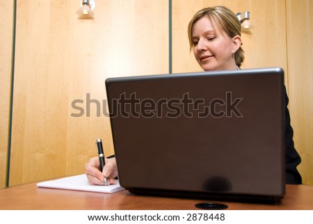 Businesswoman in a board room with his grey laptop