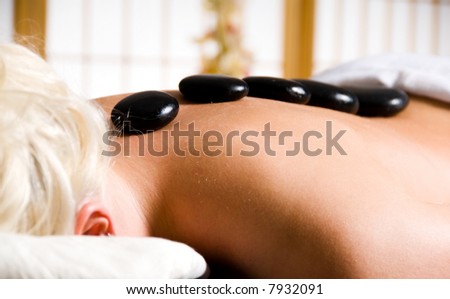 woman getting a hot stone massage at a day spa