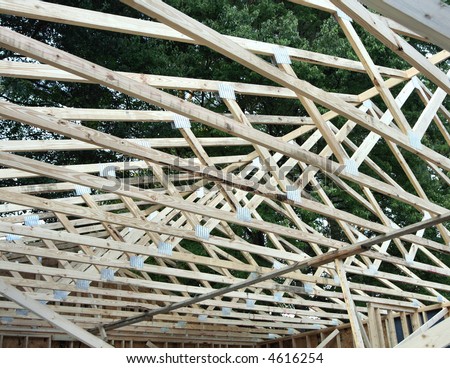 A wood frame roof under construction.  Wood beams and trusses.