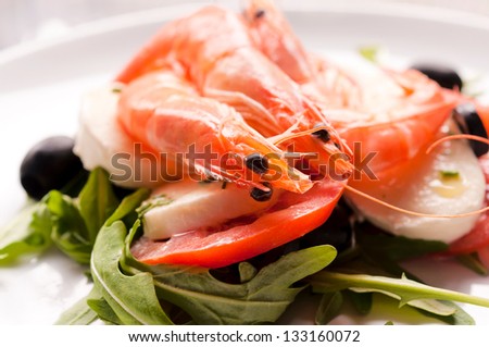 Shrimp salad with mozzarella cheese and tomato. Selective focus on the shrimp