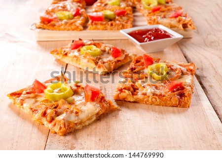 Mini white meat sandwiches with melted cheese on wooden background