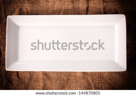 Empty white plate on the abstract background from above